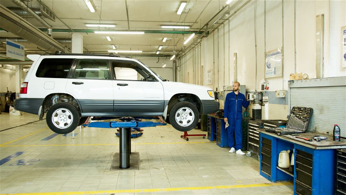 A mechanic working on a car in an automotive repair shop