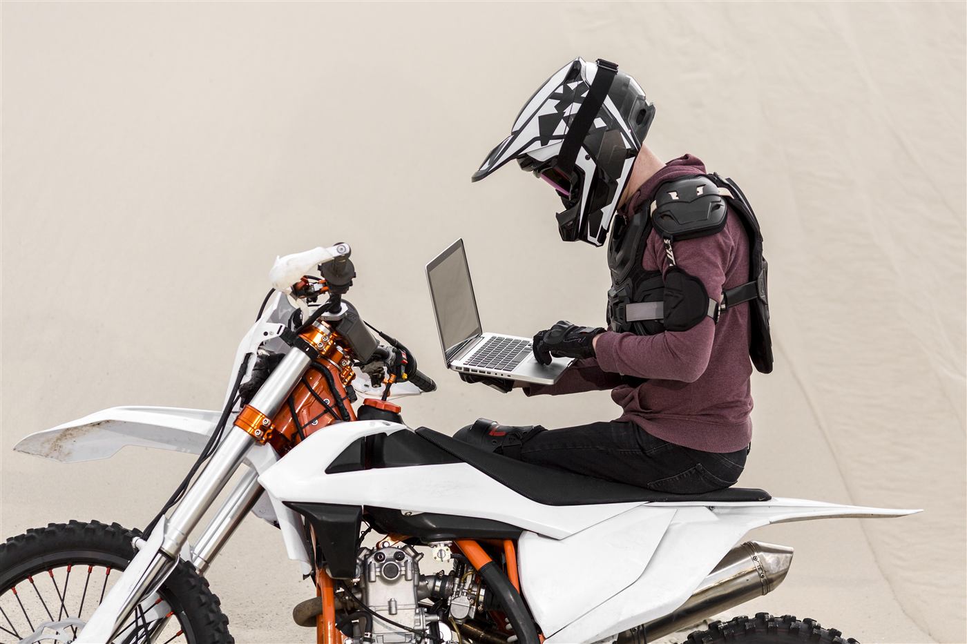 Motorcycle rider checking a laptop in the desert